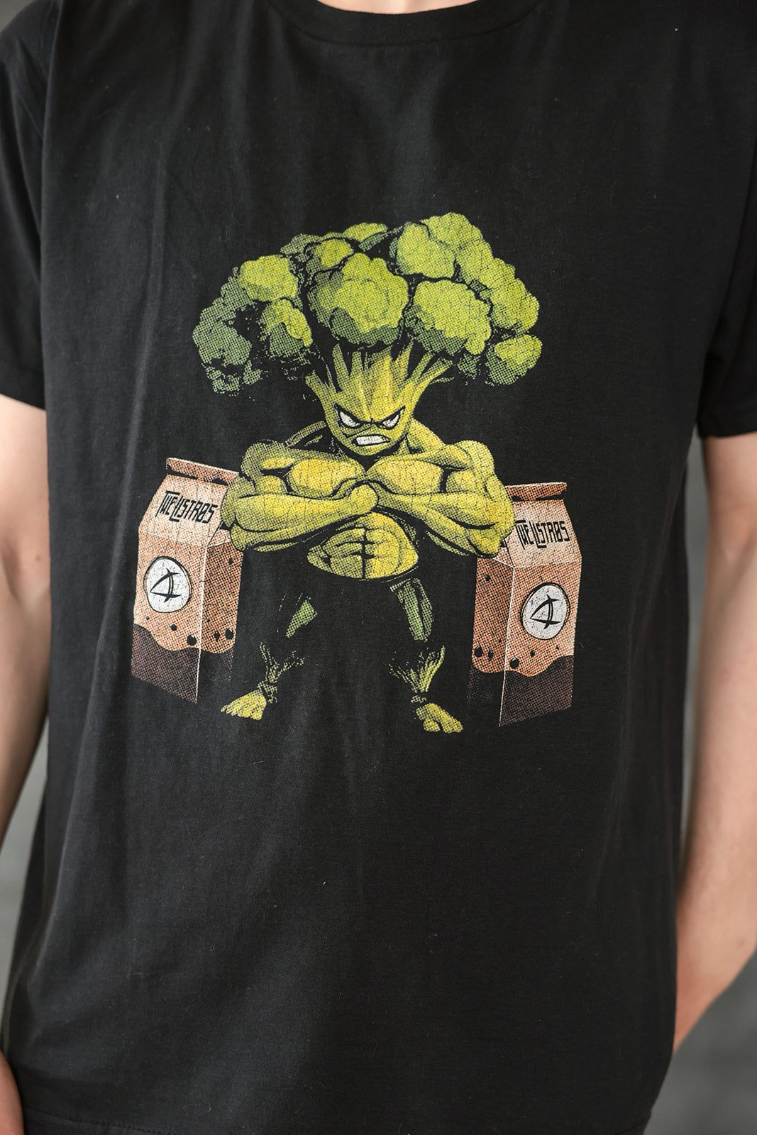 a man wearing a black t - shirt with broccoli on it