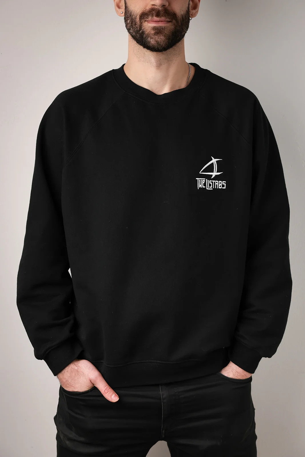a man wearing a black sweatshirt with a white logo on it