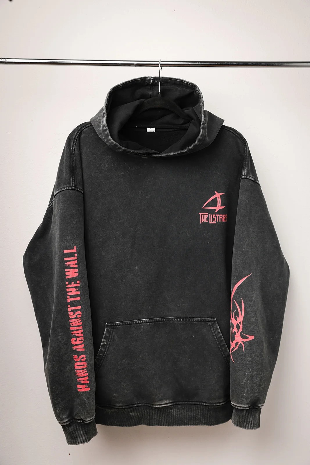 a black and pink hoodie hanging on a hanger