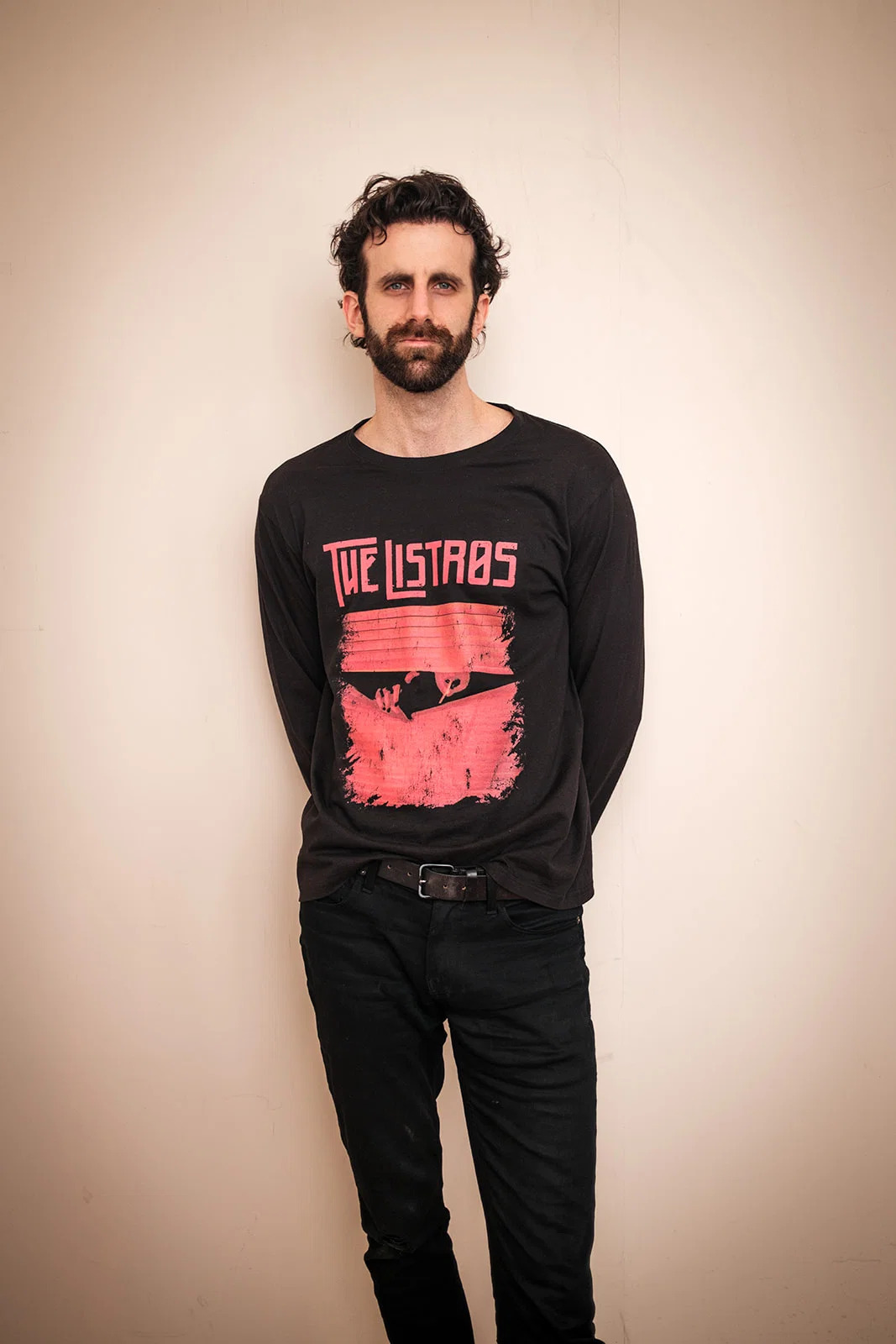 a man wearing a black sweatshirt with a red logo on it