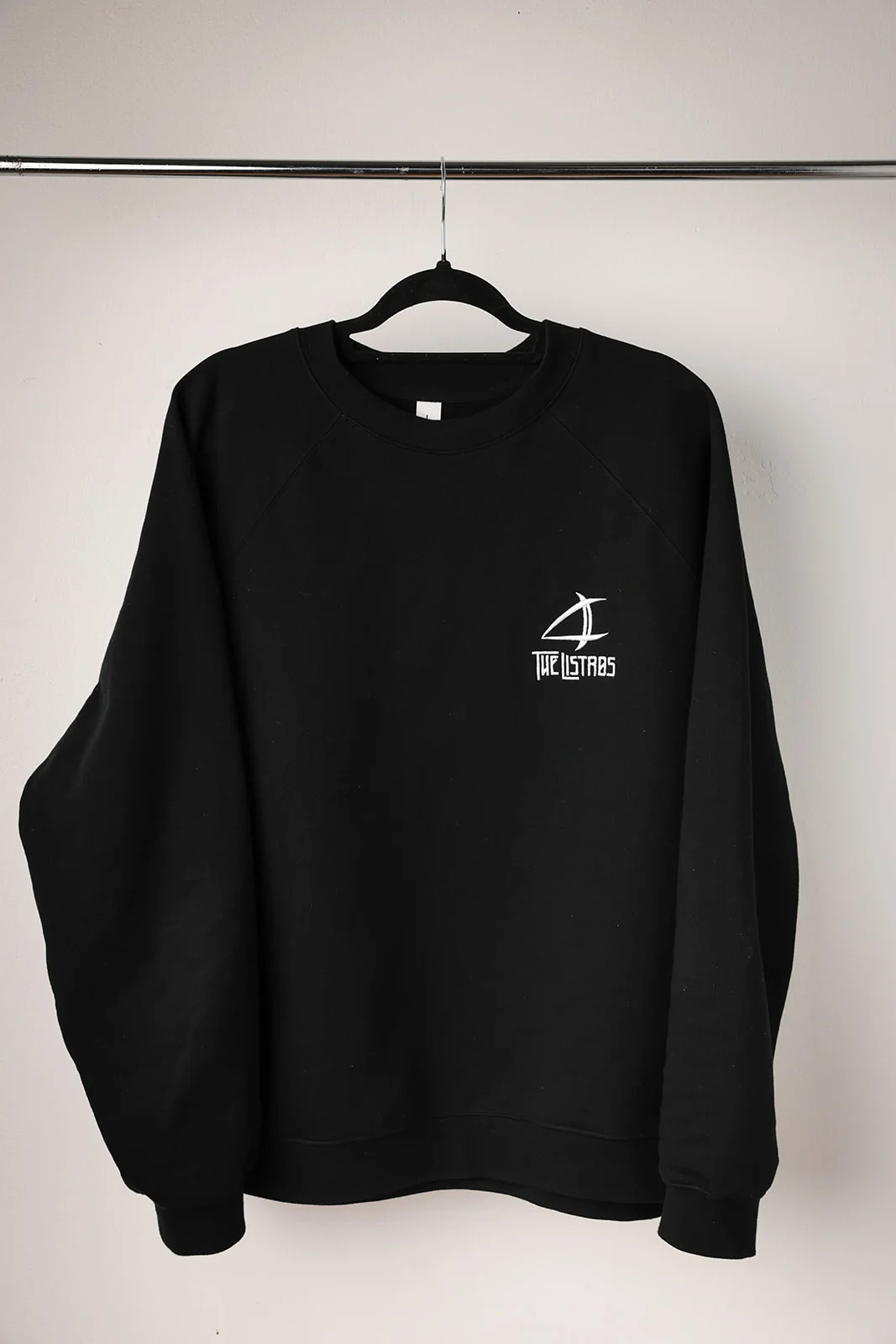 a black sweatshirt hanging on a hanger