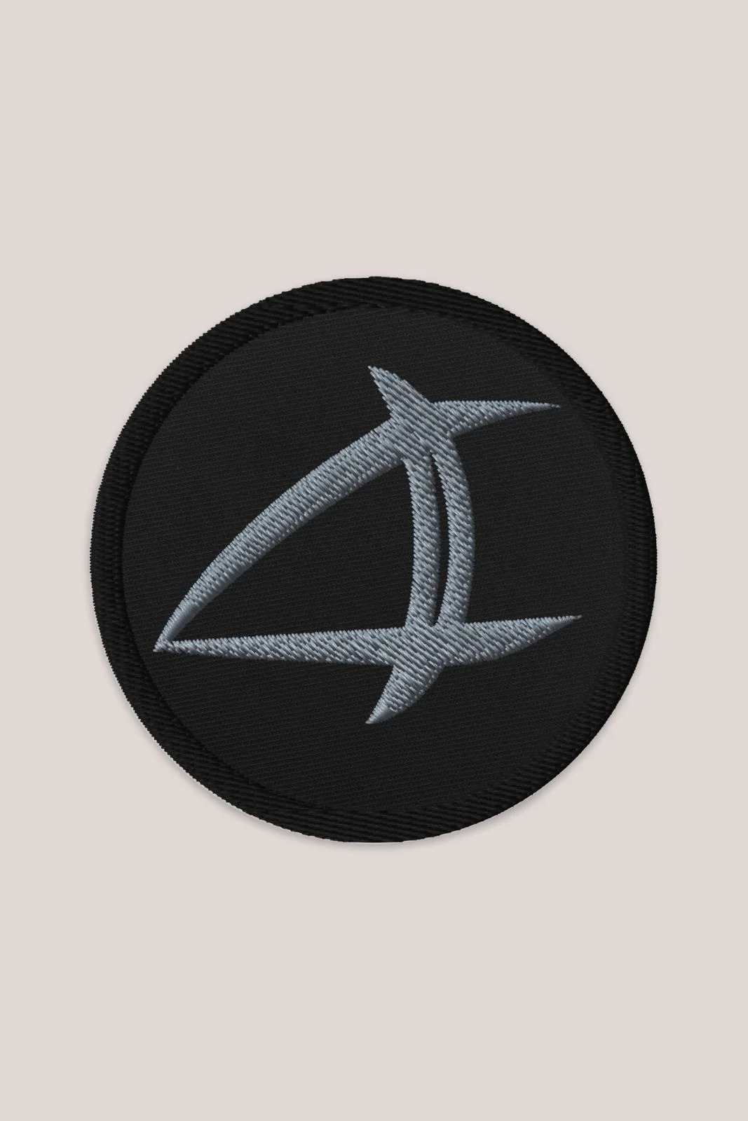 a black patch with a silver arrow on it