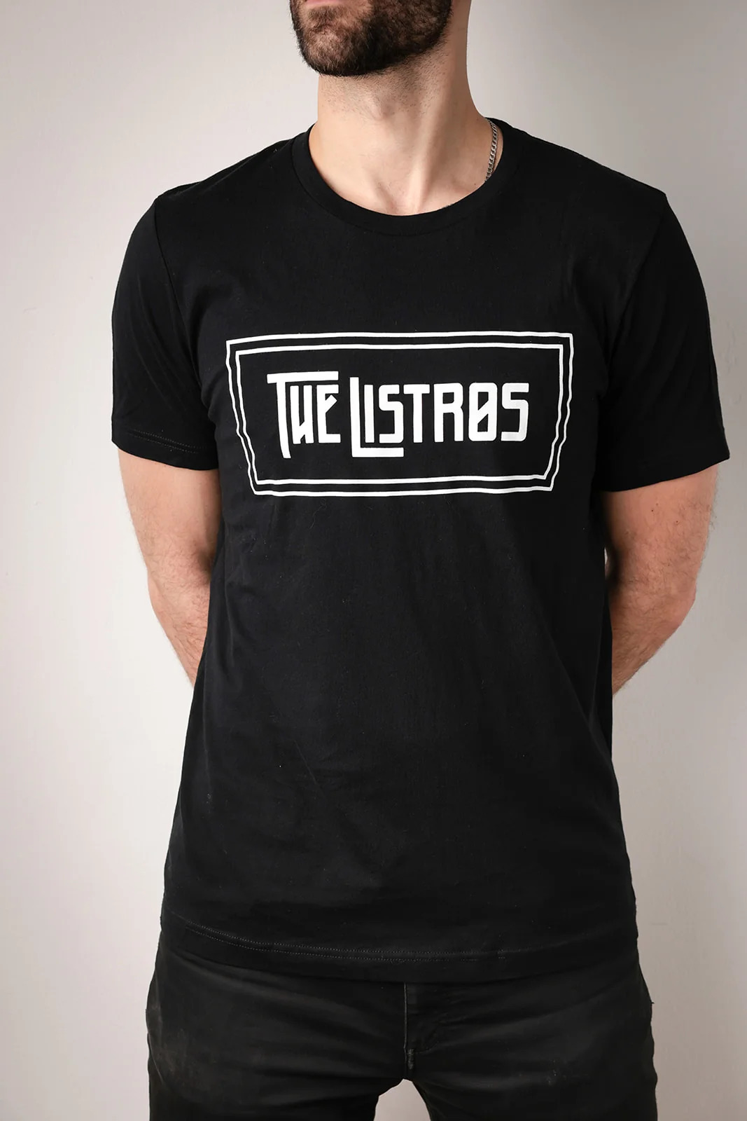 a man wearing a black t - shirt that says the listas