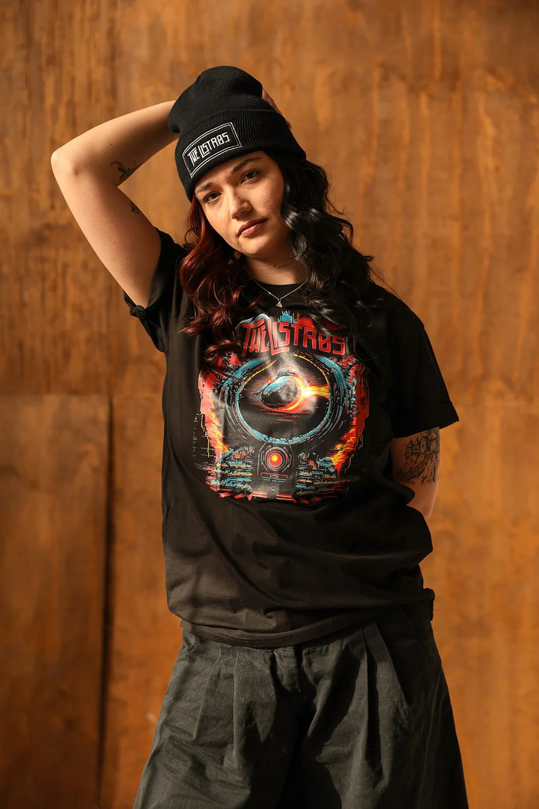 a woman wearing a black t - shirt and a beanie