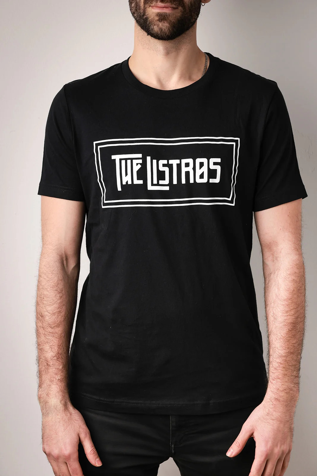 a man wearing a black t - shirt that says the listas