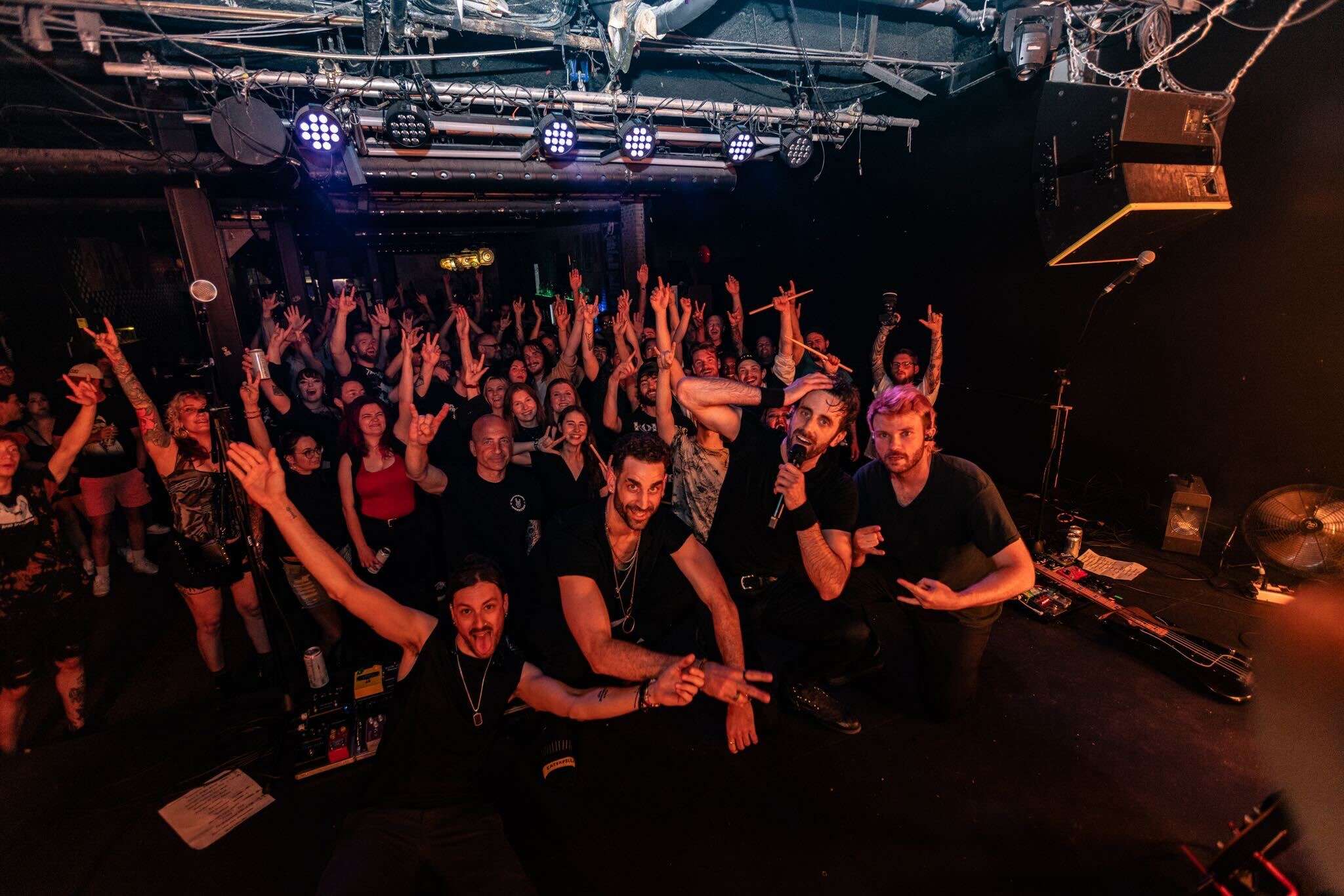 a group of people at a concert with their hands up