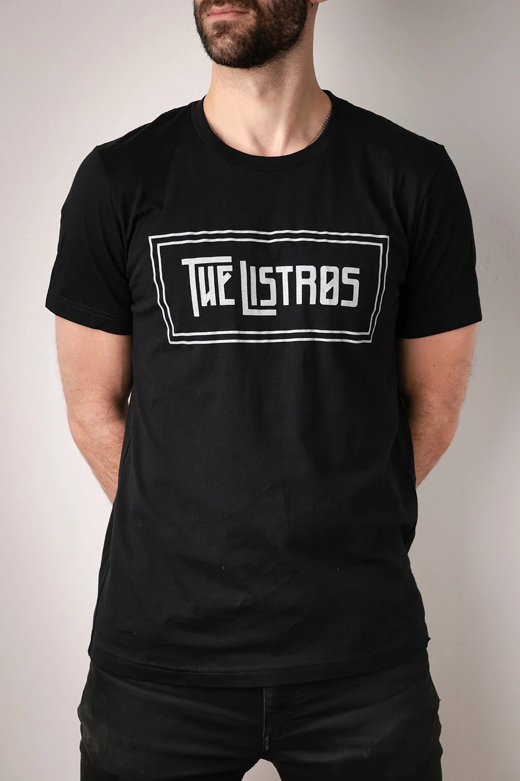 a man wearing a black t - shirt that says the listas