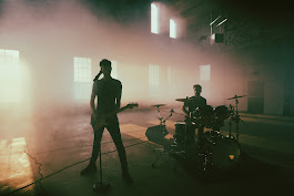two men playing drums in a dark room