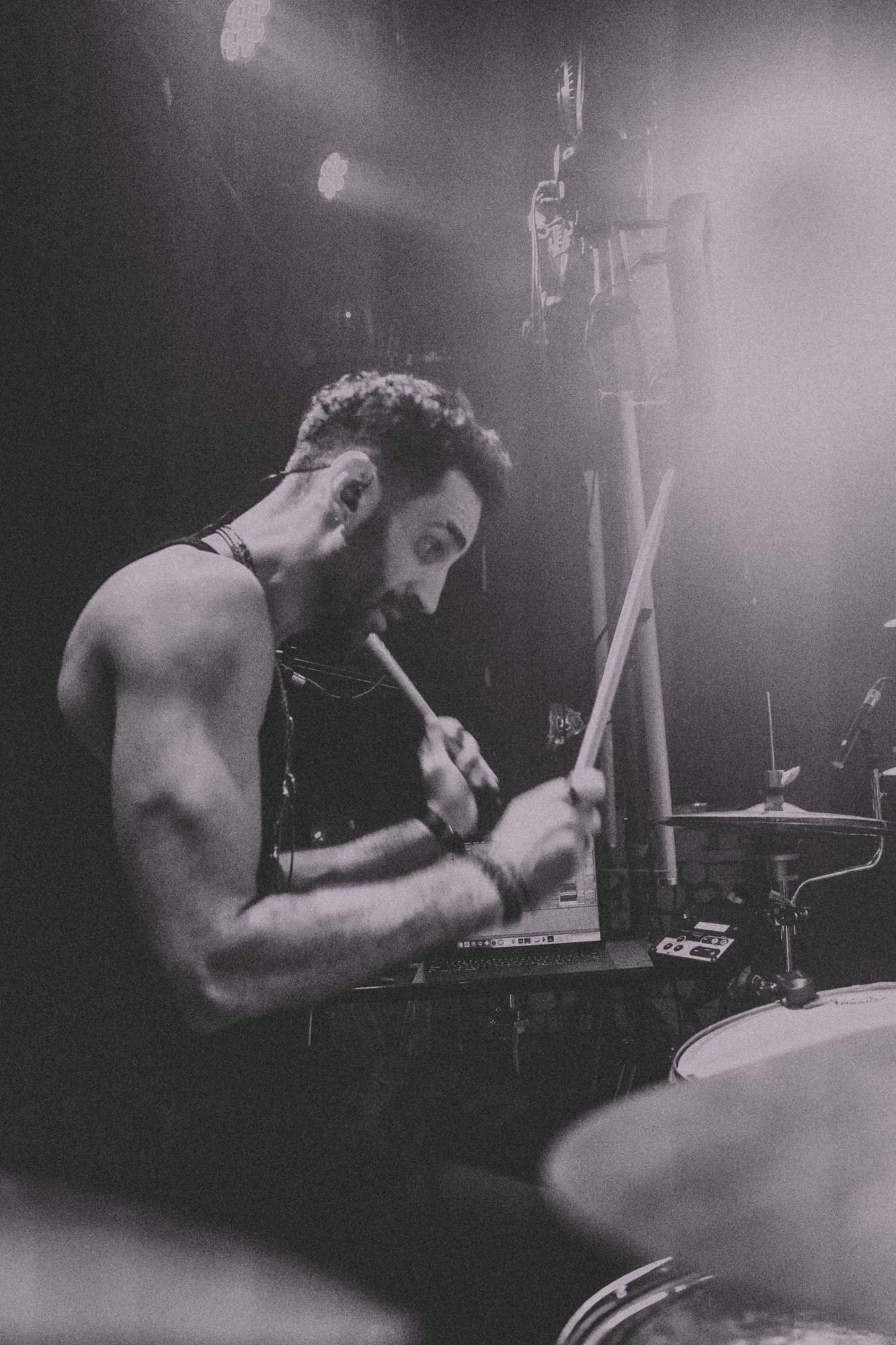a black and white photo of a man playing drums