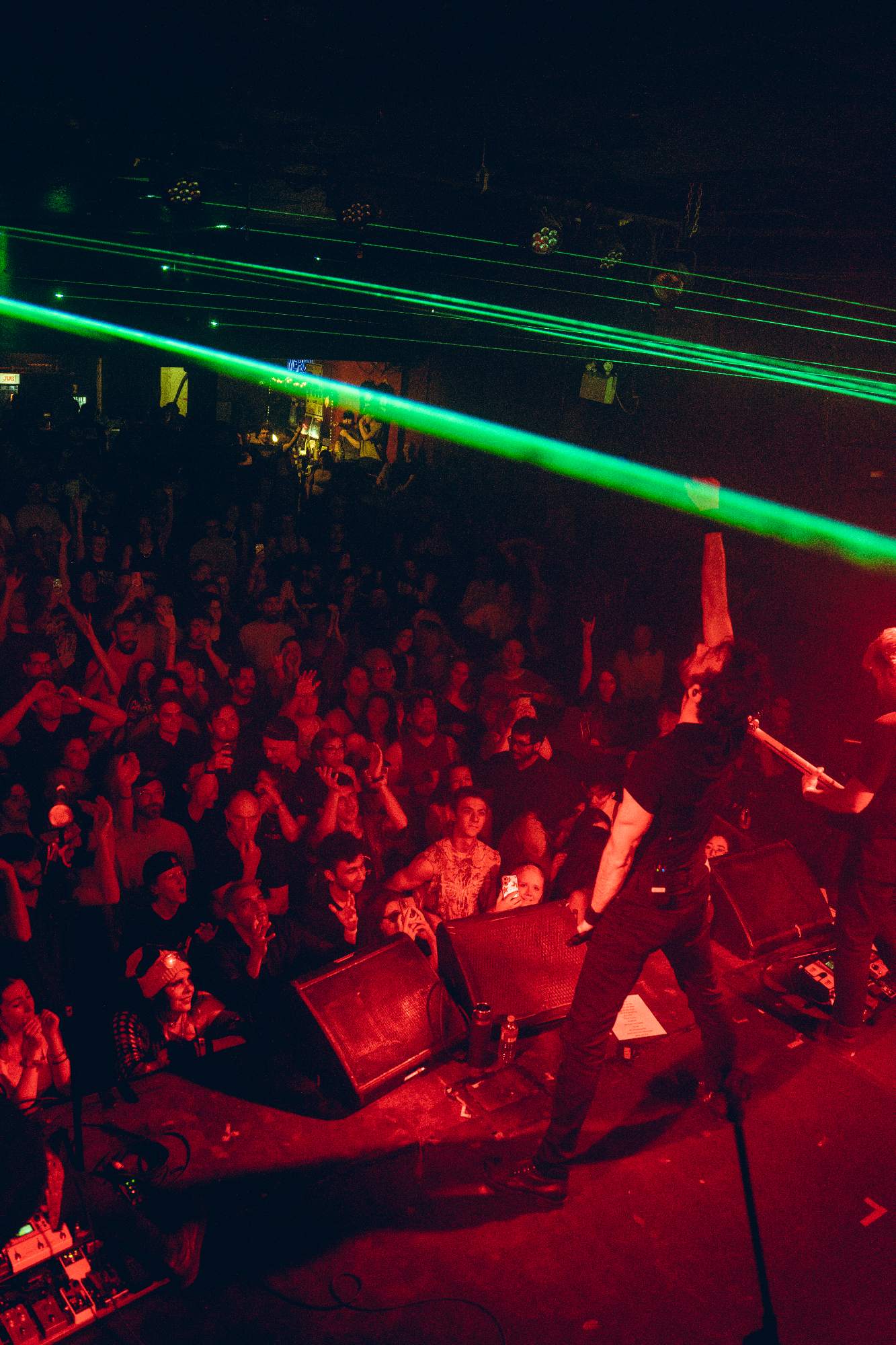 a man is playing a guitar on stage in front of a crowd
