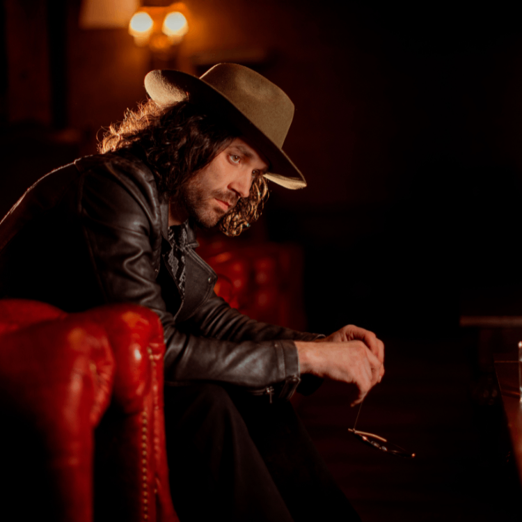 a man in a hat sitting on a red chair