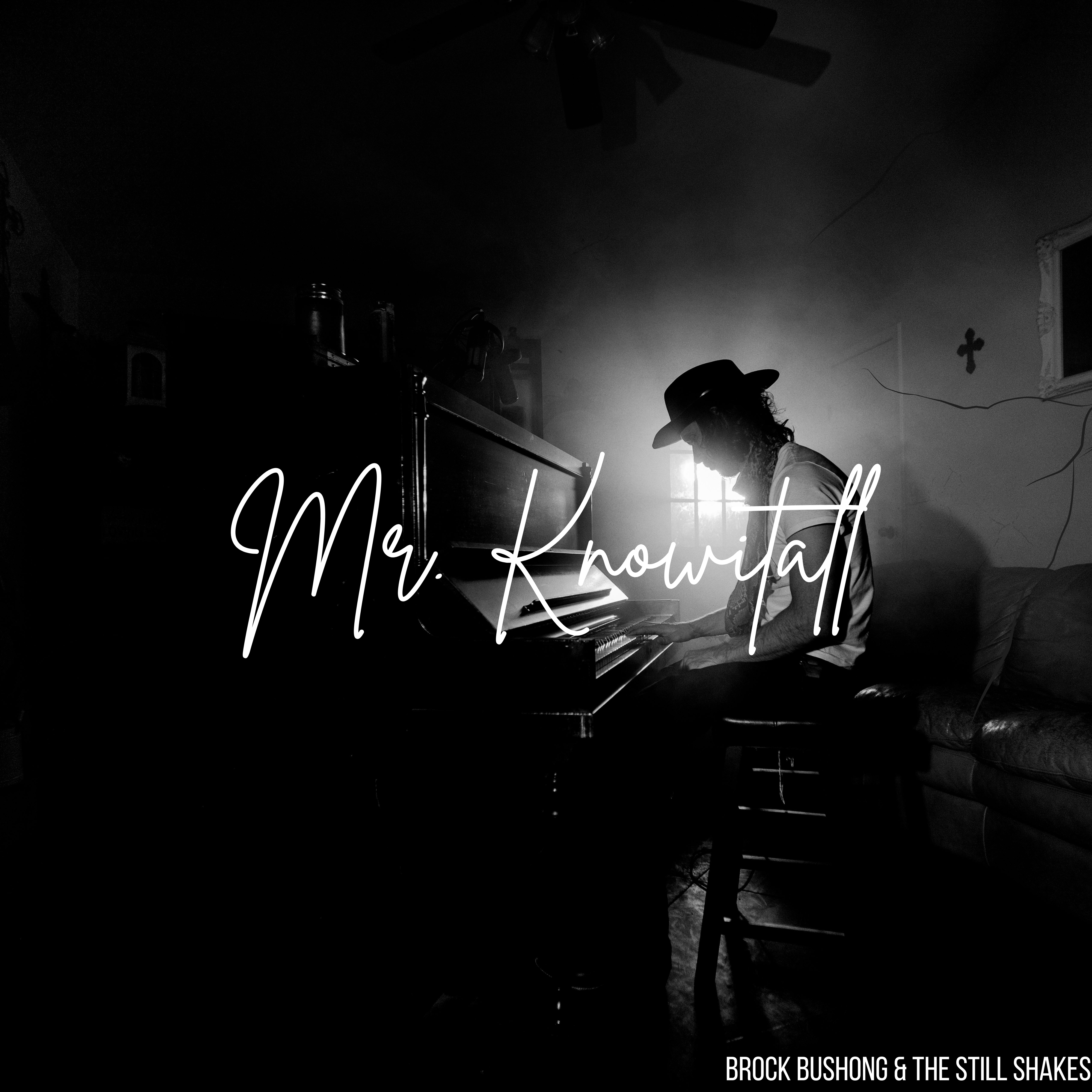 a black and white photo of a man sitting at a piano