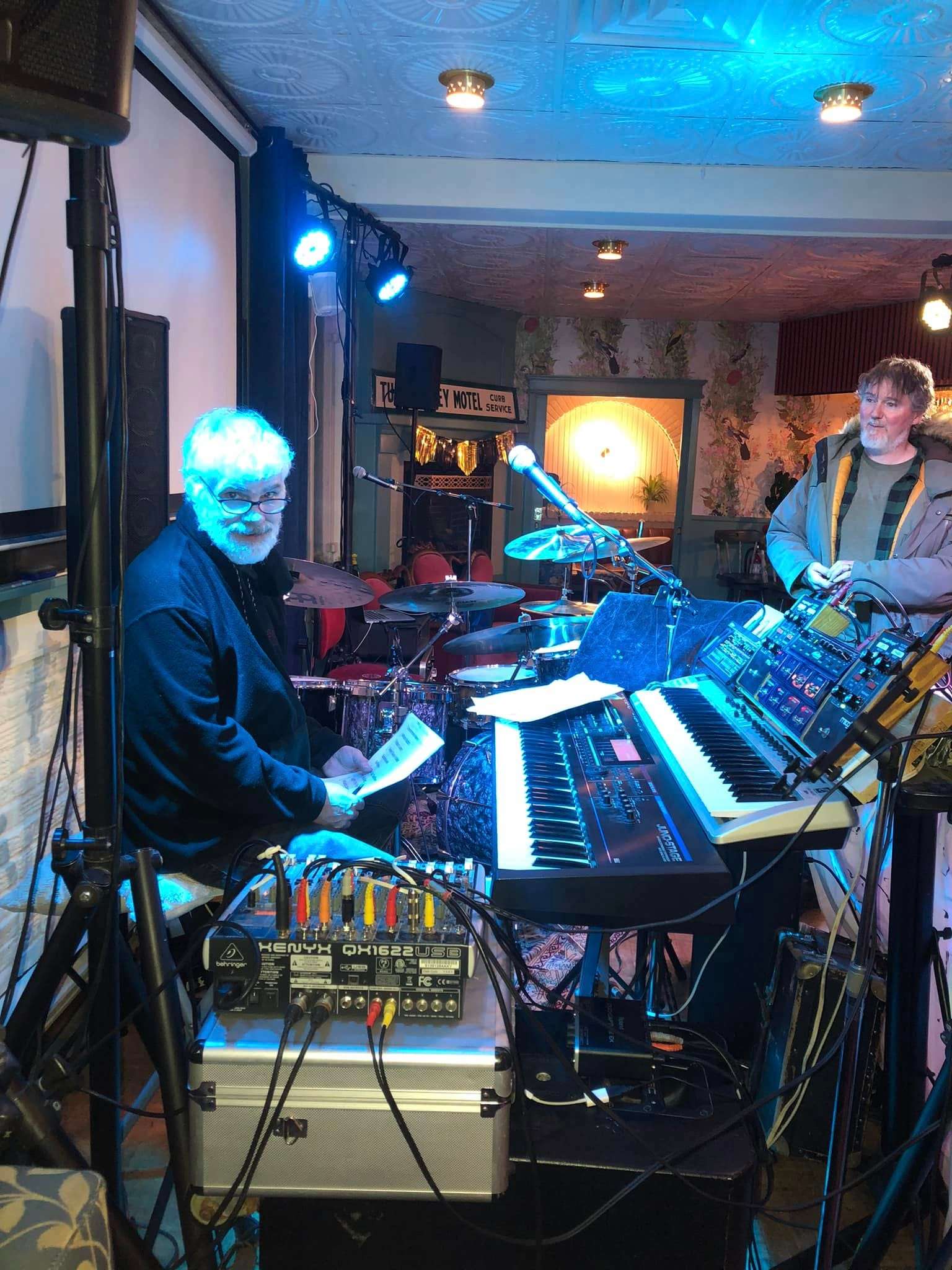 a group of people playing keyboards in a room