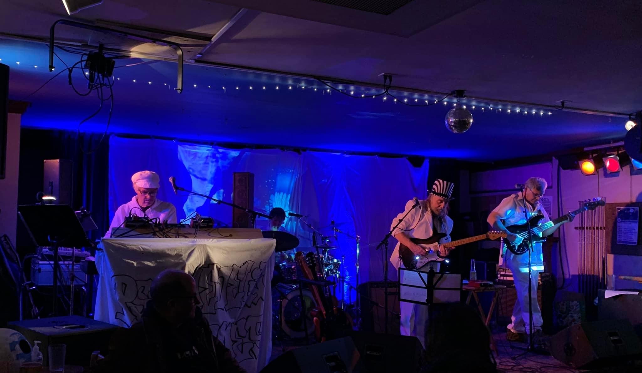 a group of people playing music in a dark room