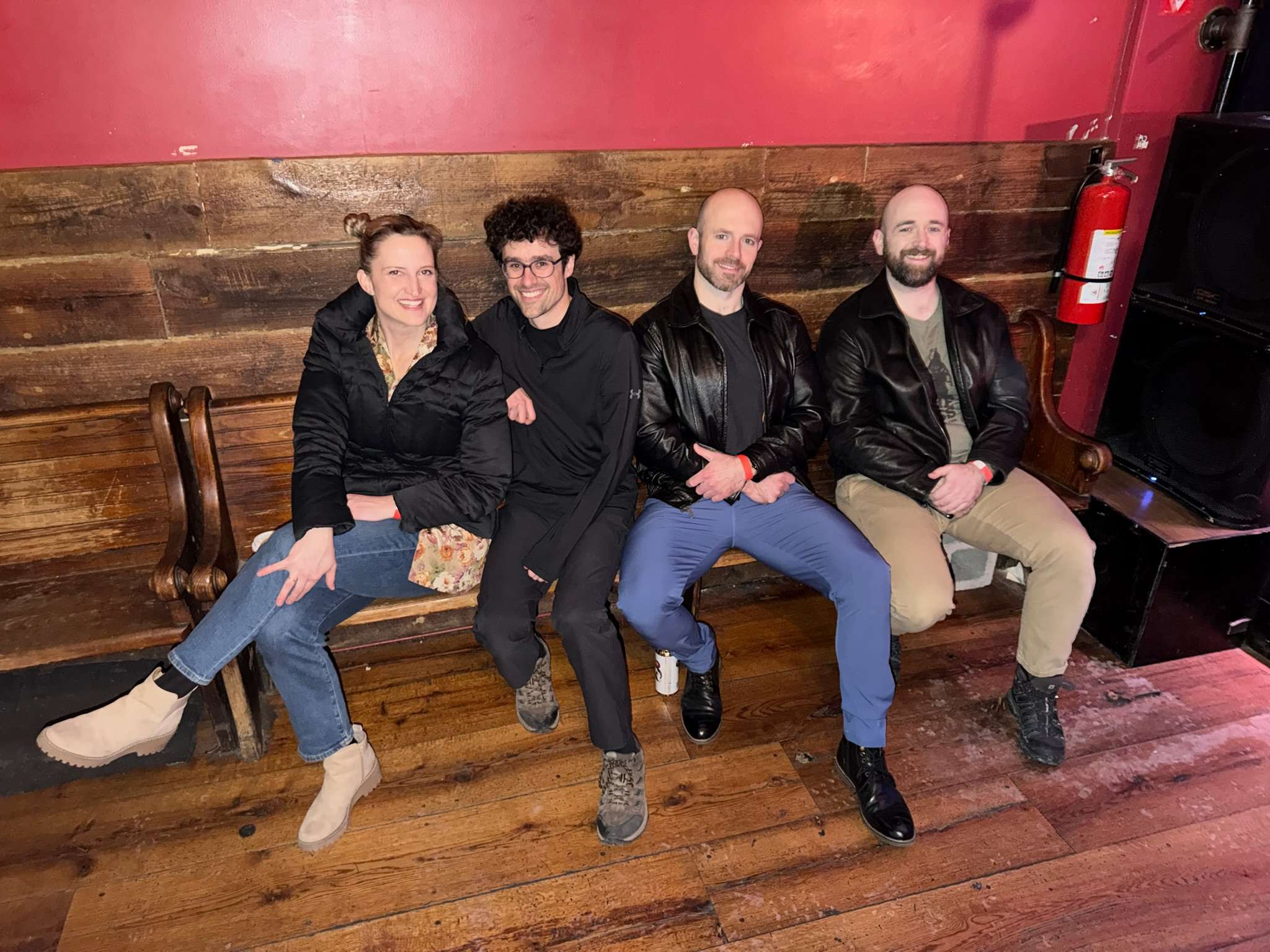 a group of people posing on a wooden bench