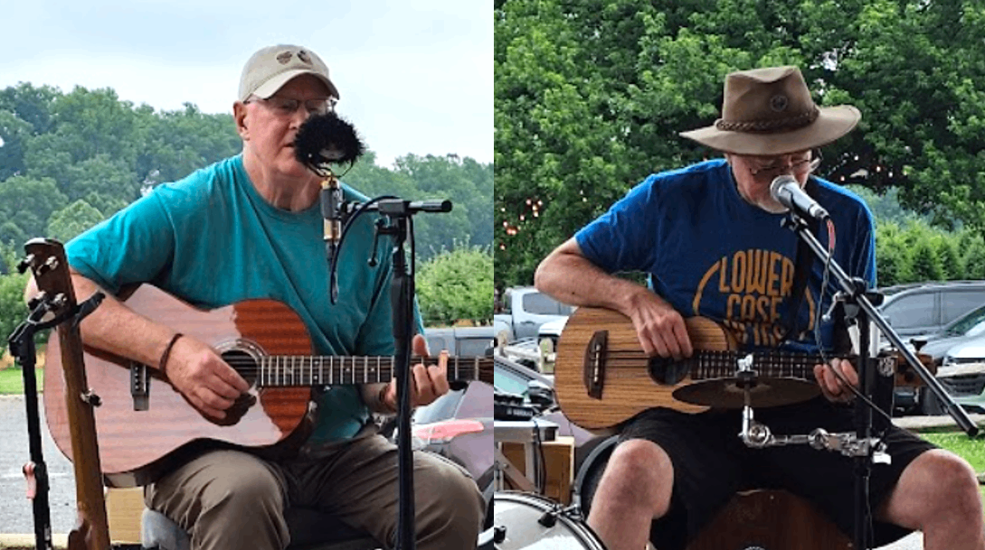 two men playing acoustic guitars in front of a microphone