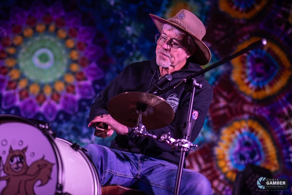 a man in a hat playing drums on stage