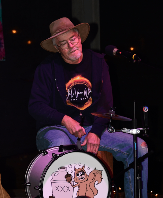 a man in a hat is playing drums