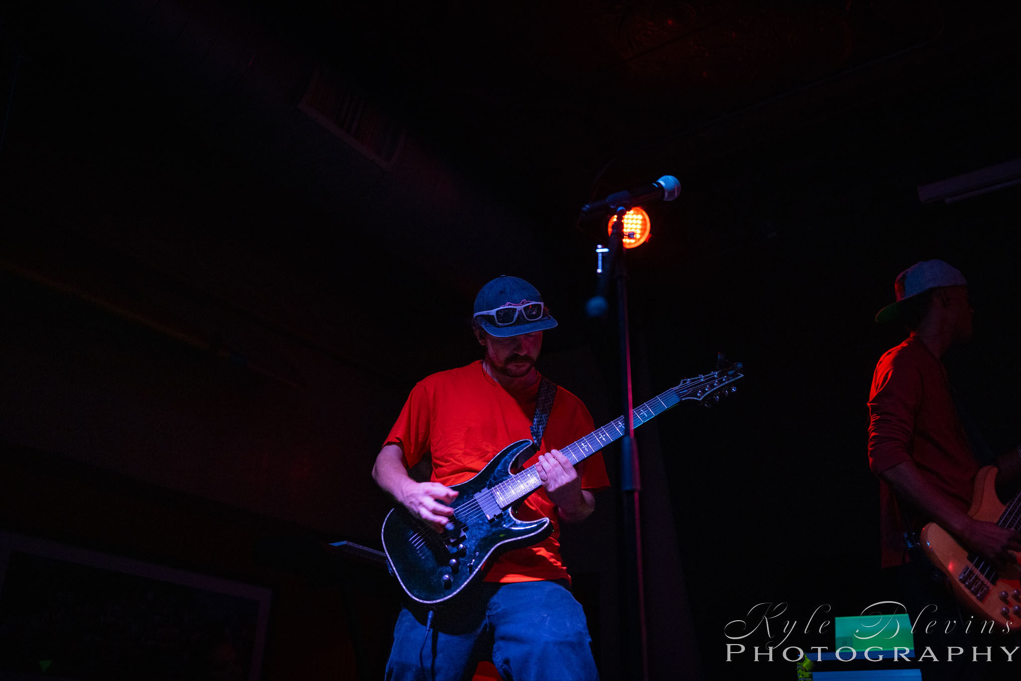 a man playing a guitar in a dark room
