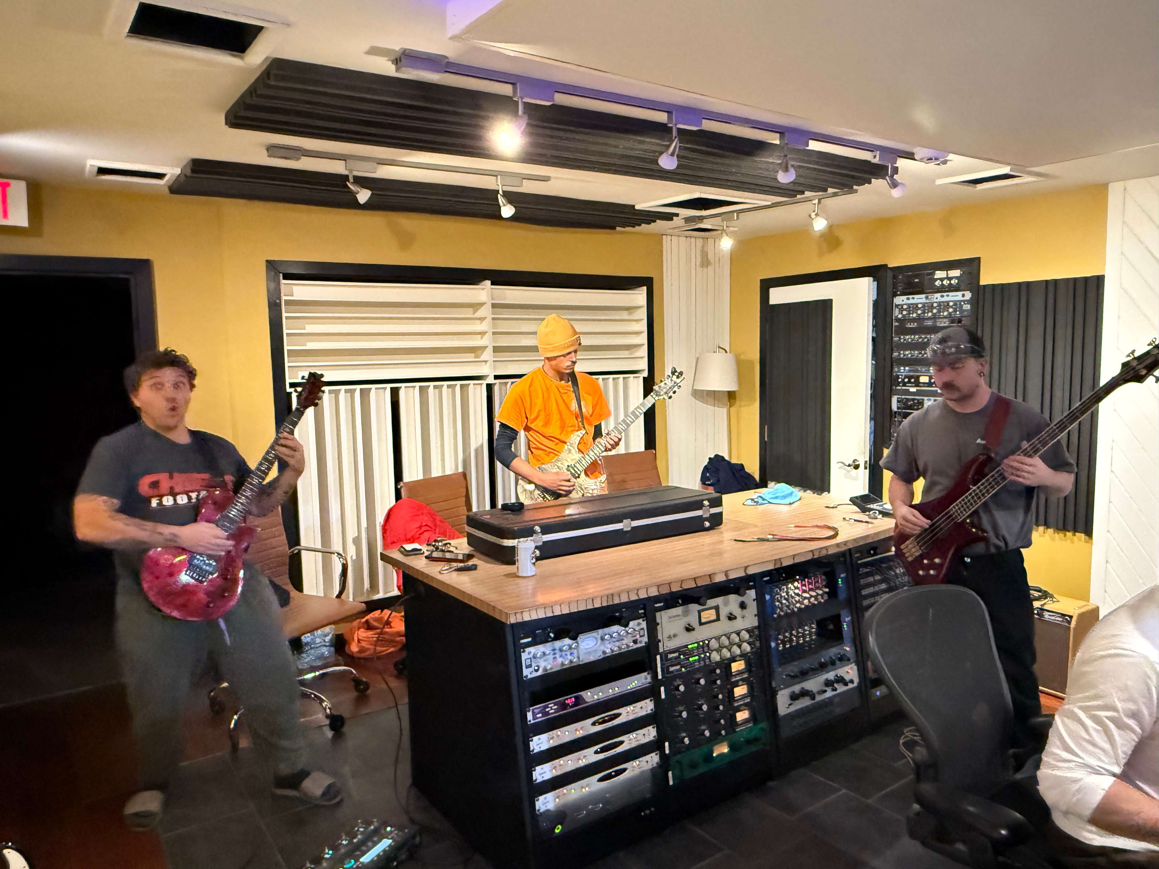 a group of people playing music in a recording studio