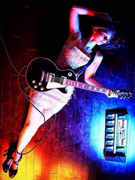 a woman laying on the floor with an electric guitar