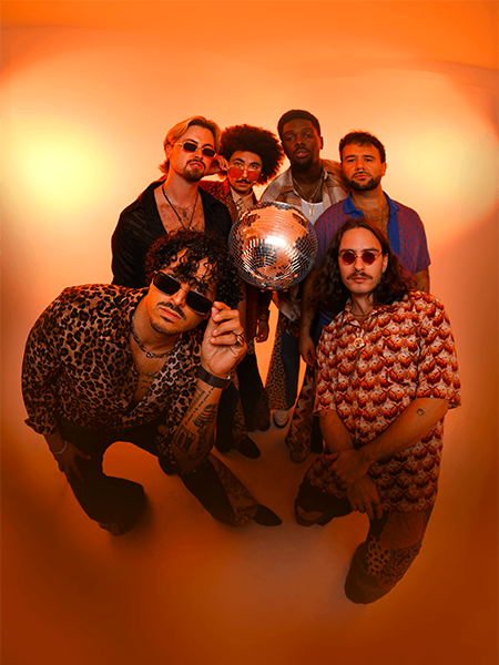 a group of people posing in front of an orange background