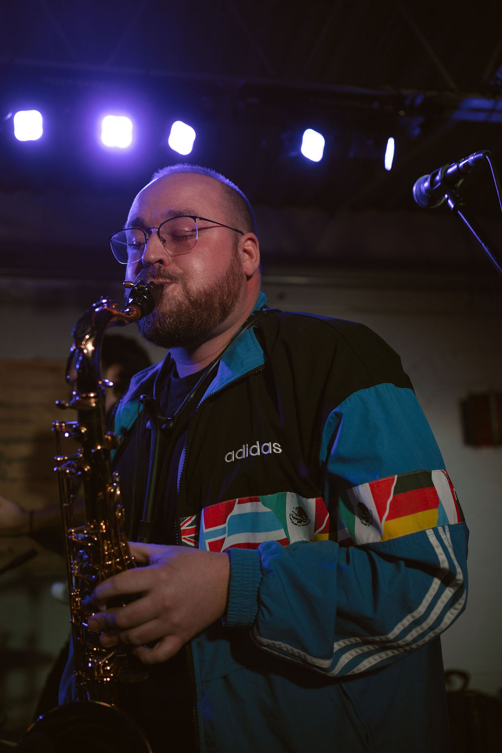a man playing a saxophone in front of a microphone