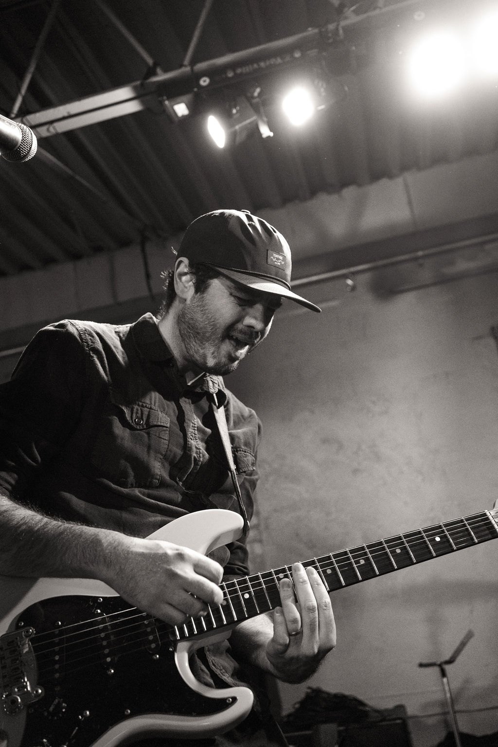 a man playing an electric guitar in front of a microphone